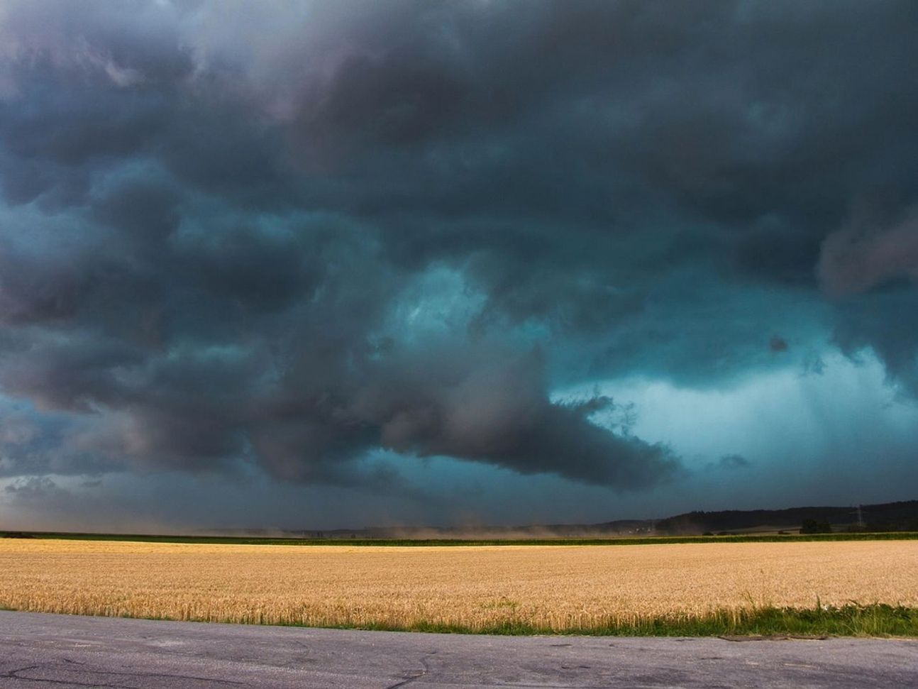 Set of four storm cloud photographs arranged in sequence to show the progression of a weather system