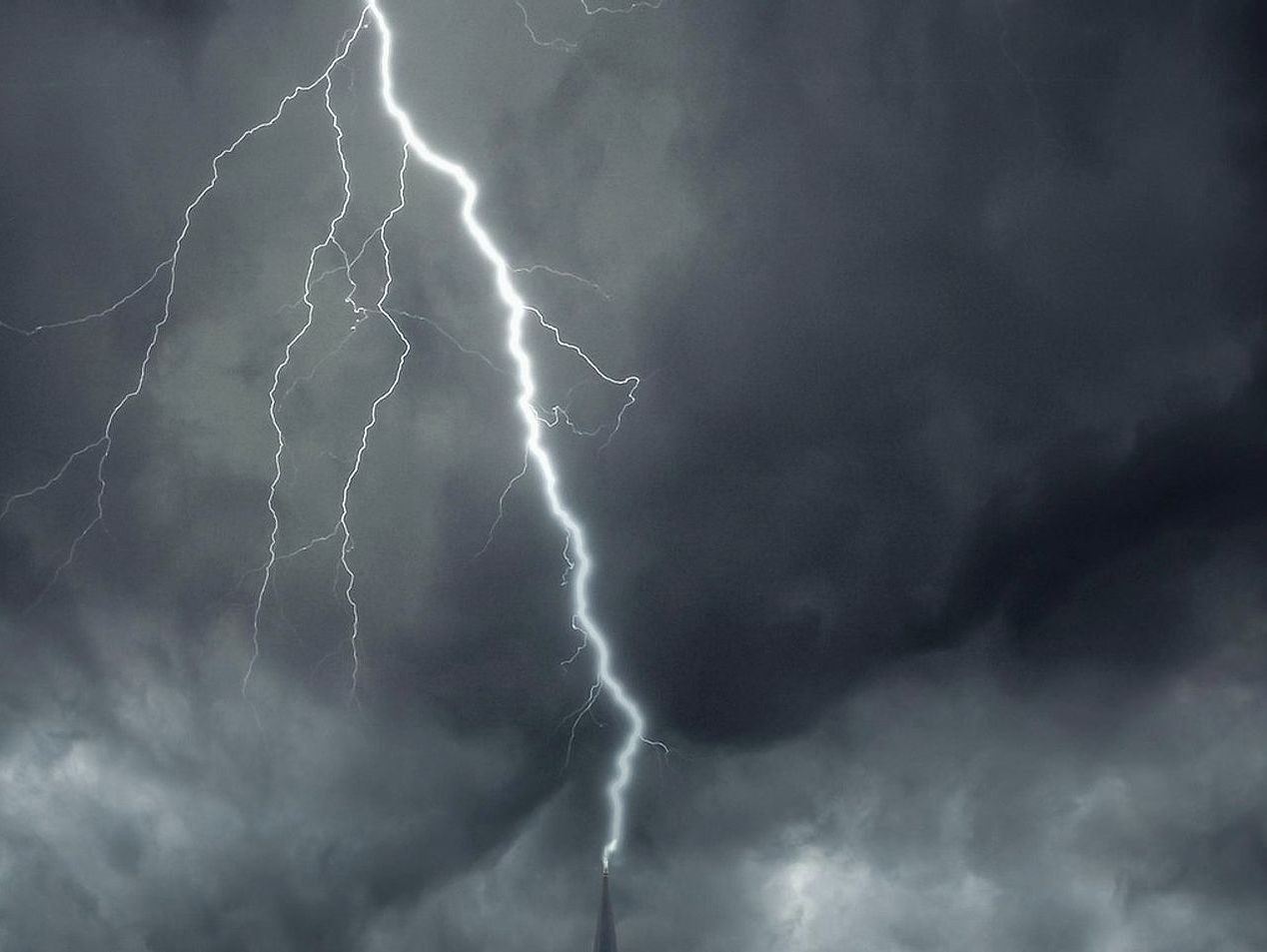 Photographer framing a distant lightning bolt through camera viewfinder